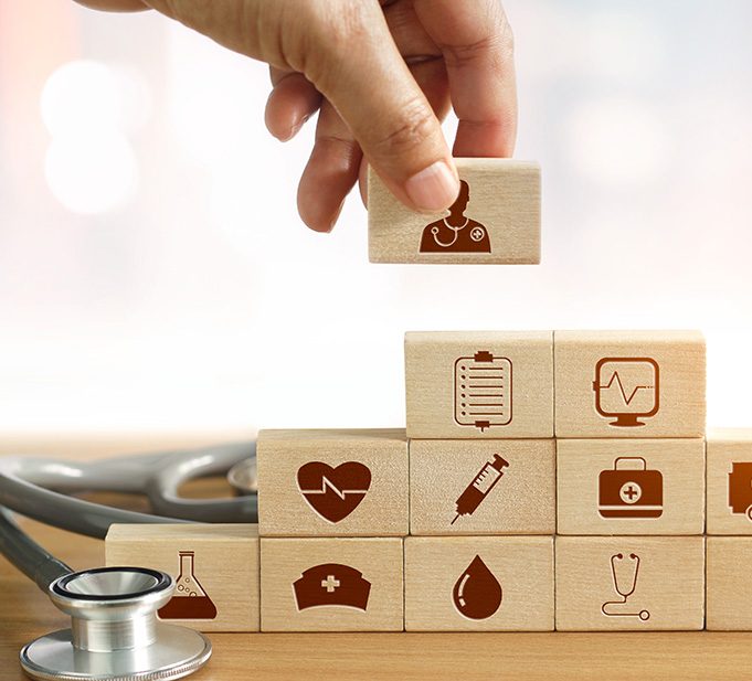 Health Insurance concept, Hand of medicine doctor holding wood block and stacking with icon healthcare medical and stethoscope on background.