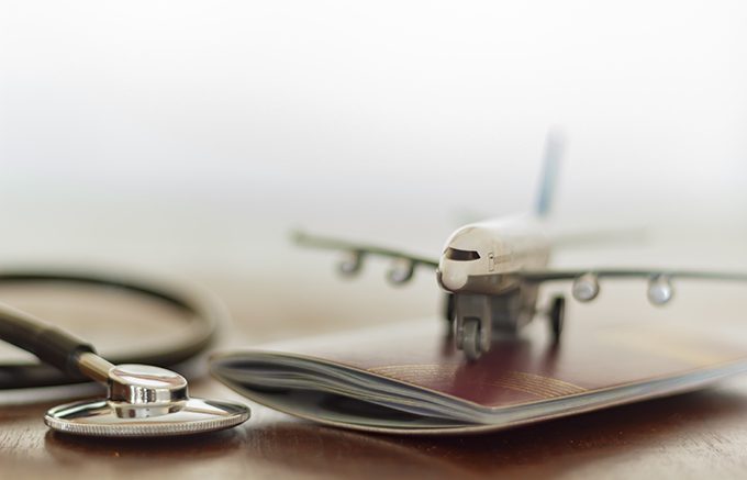 Stethoscope , passport document and airplane: Medical Travel concept