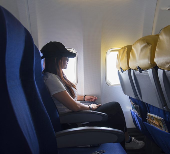 Women traveling by an airplane. Women sitting by aircraft window and looking outside.